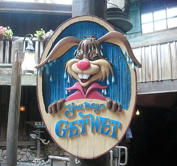 A photo of a Splash Mountain Sign featuring the text you may get wet with Brer Rabbit